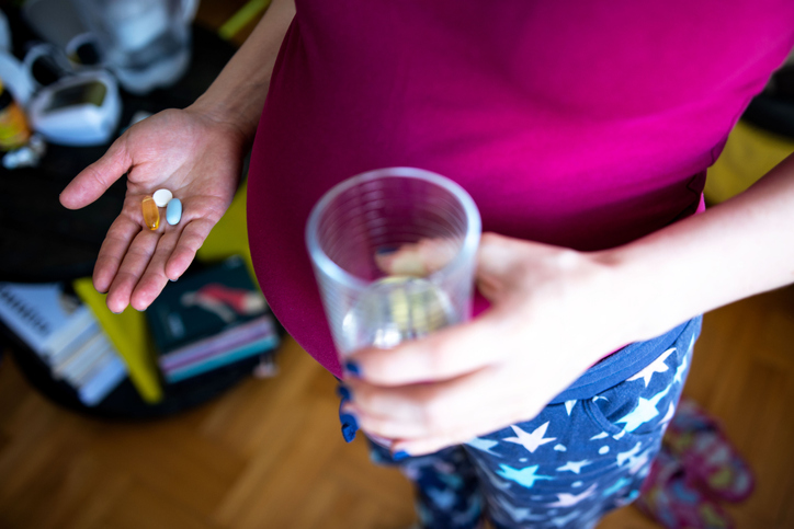 kobieta w ciąży przyjmująca witaminy